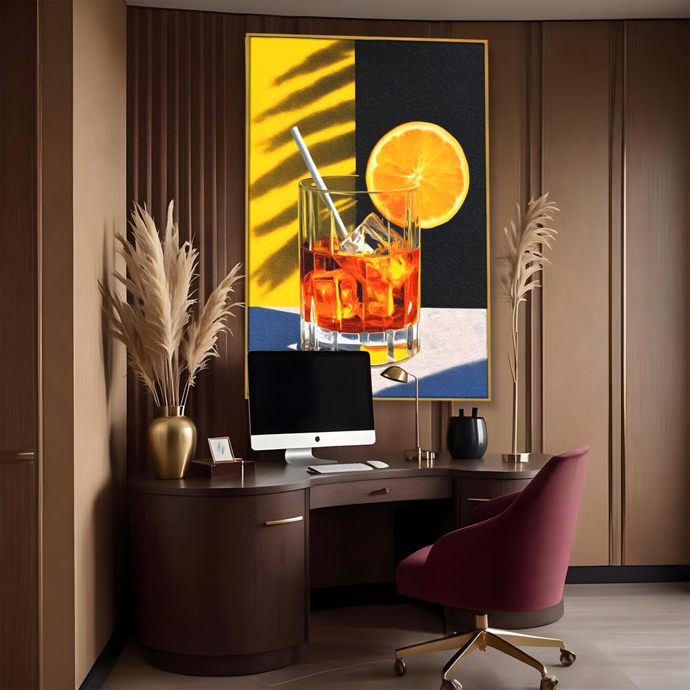 Tablou canvas cu ilustratie cu pahar de cocktail si portocala, in rama de aluminiu auriu, pe perete intr-un birou